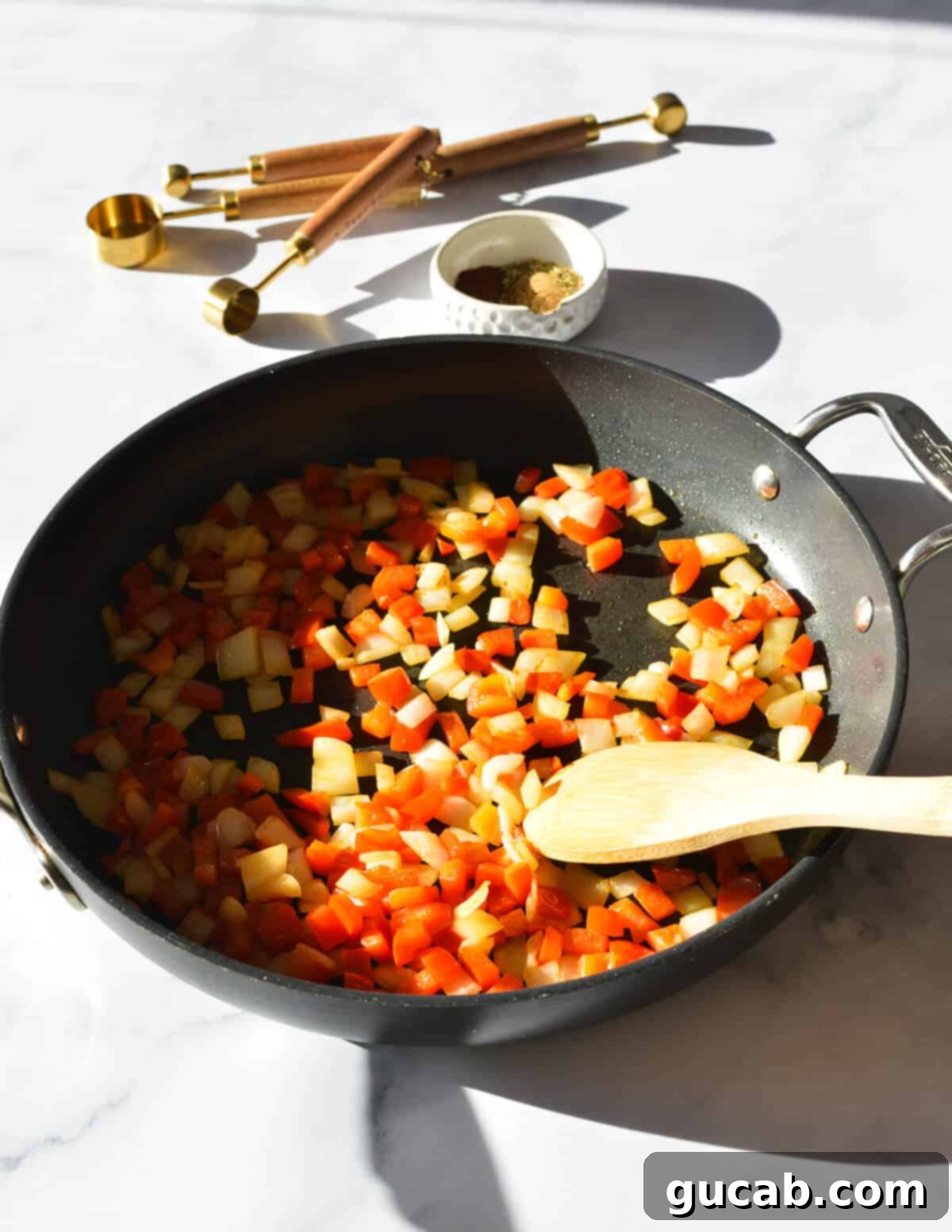 Sautéing a colorful mixture of red bell peppers and onions in a hot skillet, as they become tender and intensely aromatic, preparing them for the black bean burger mixture.