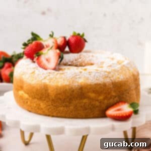 A beautiful homemade angel food cake presented on a cake stand, ready to be sliced and served.