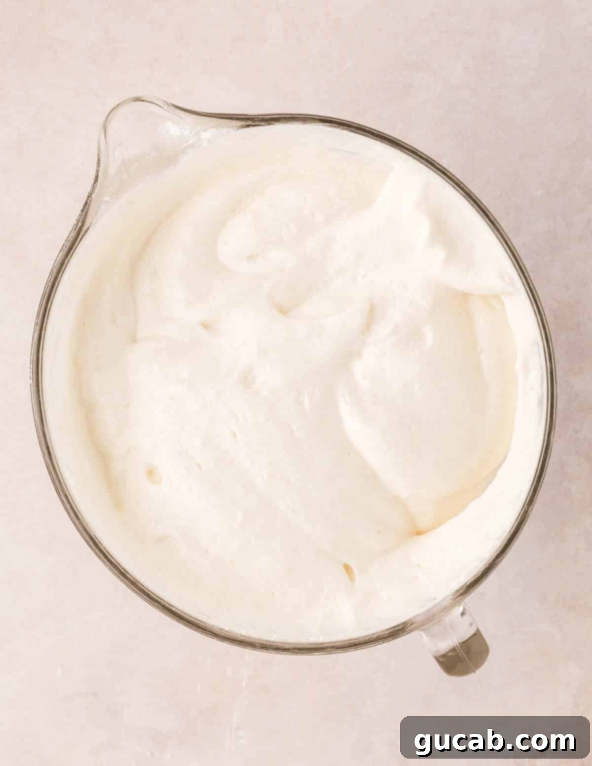 Light and airy angel food cake batter in a mixing bowl after flour has been gently folded in.