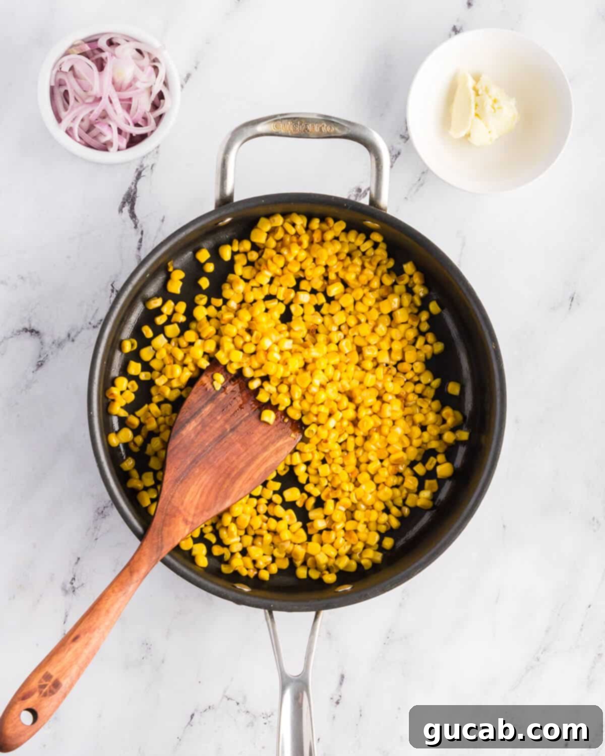 Sweet corn kernels spread evenly in a hot skillet, beginning to caramelize.