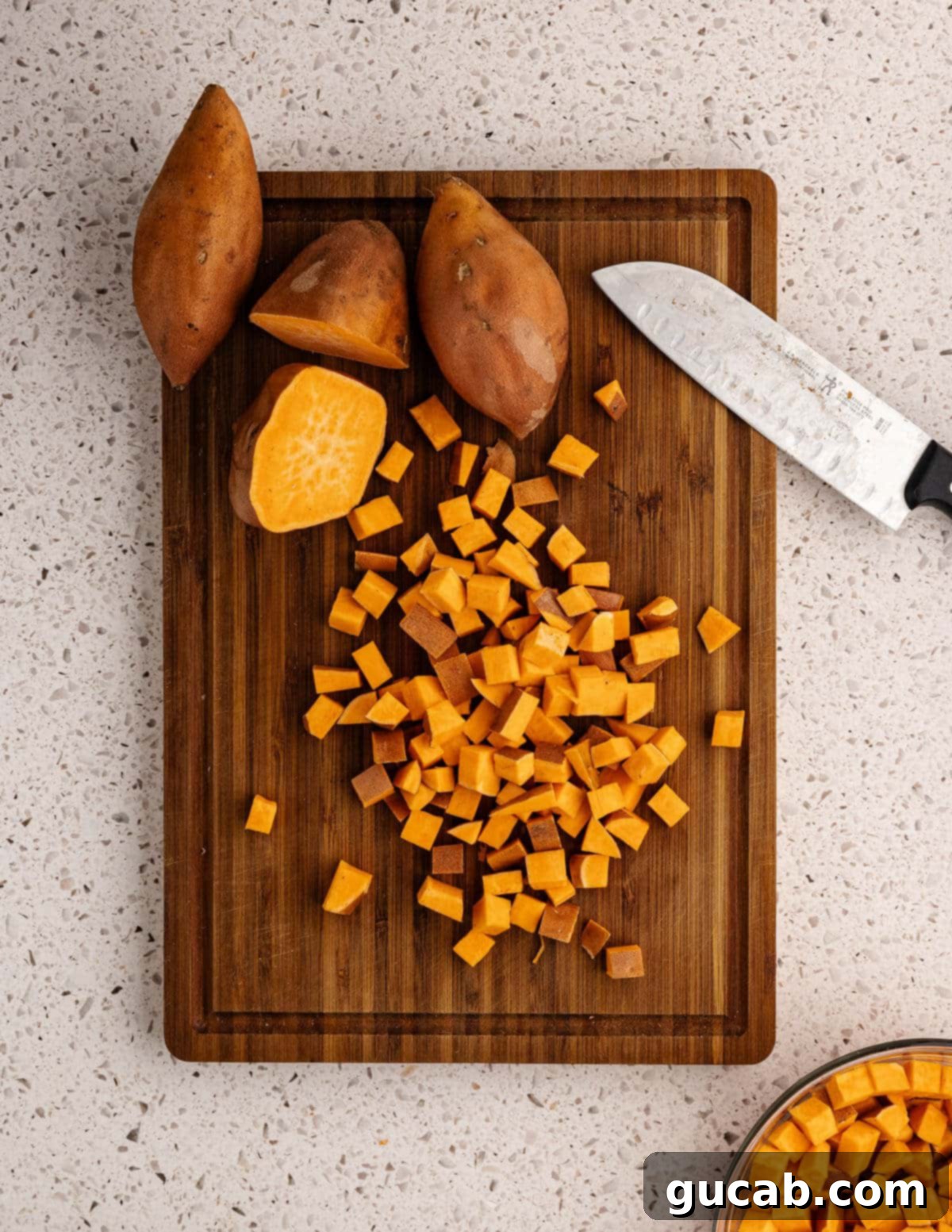 diced sweet potatoes on a cutting board.