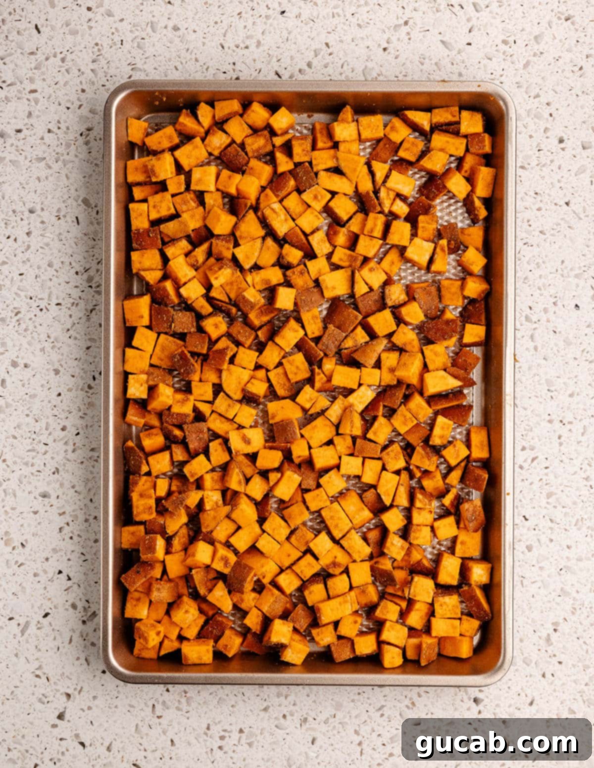 cut up sweet potatoes on a sheet pan.