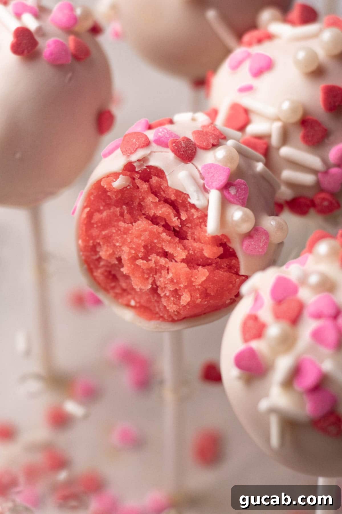 17 Heartwarming Valentine's Day Desserts 6 strawberry cake pop with a bite taken out of it, showing a festive Valentine's treat