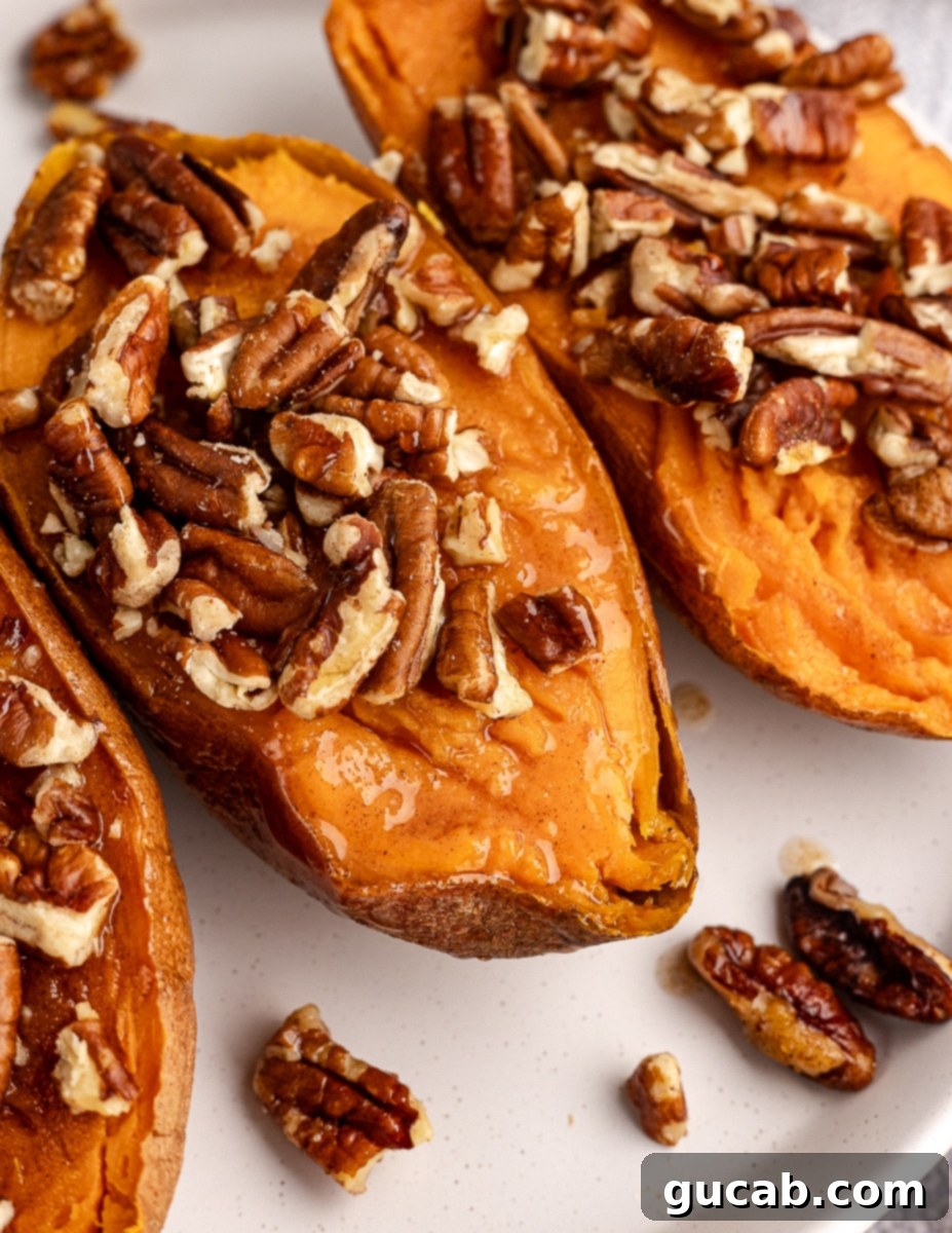 close up of baked sweet potatoes with toasted pecans on top. 
