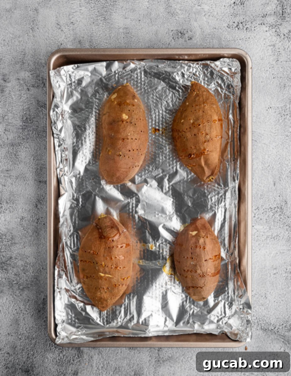 baked sweet potatoes on a sheet pan with aluminum foil. 