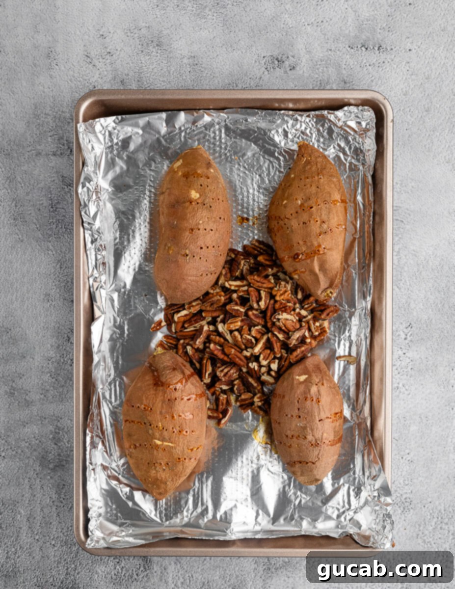 sweet potatoes on a pan with toasted pecans in the center. 