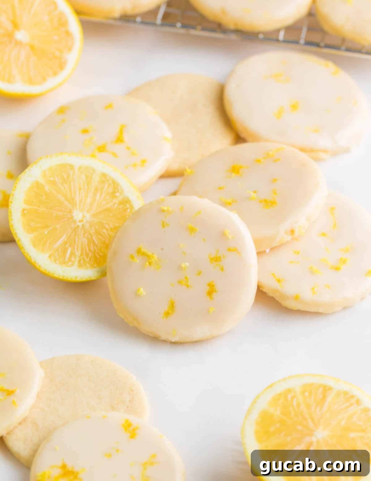Sweet and Zesty Lemon Cookies 2 lemon glazed sugar cookies with lemon zest on top.