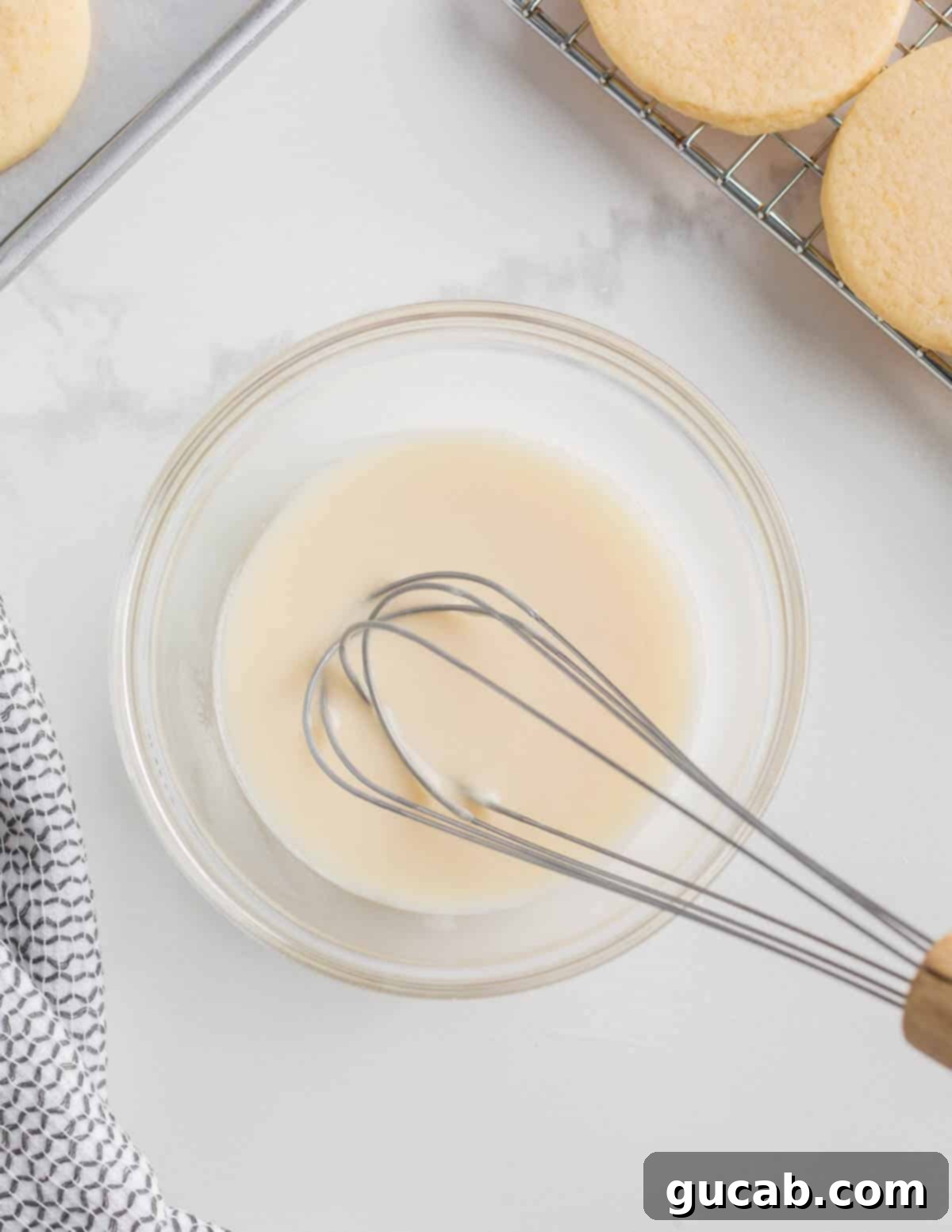 Sweet and Zesty Lemon Cookies 11 a bowl of lemon glaze with a whisk in it.