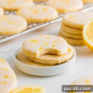 Sweet and Zesty Lemon Cookies 14 stack of glazed lemon cookies on a small plate.