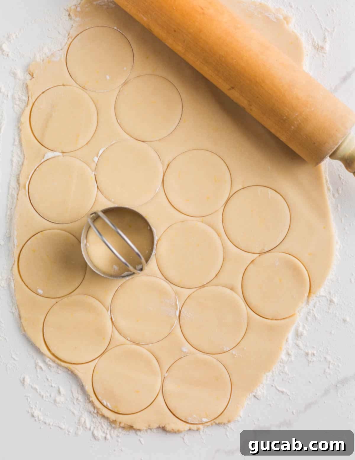 Sweet and Zesty Lemon Cookies 8 sugar cookie dough rolled out with round cookies cut out of it.