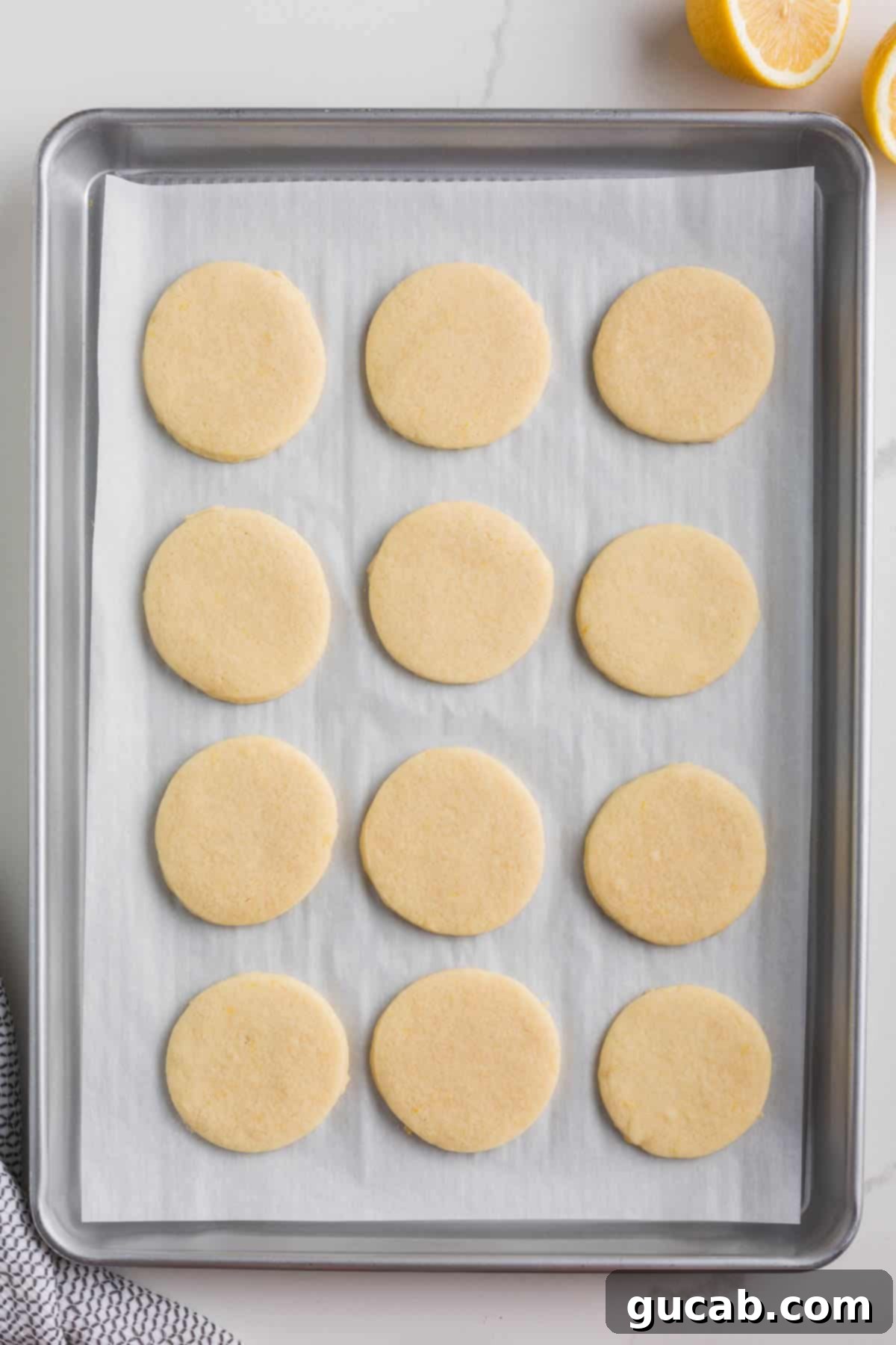 Sweet and Zesty Lemon Cookies 10 baked round lemon sugar cookies on a sheet pan.