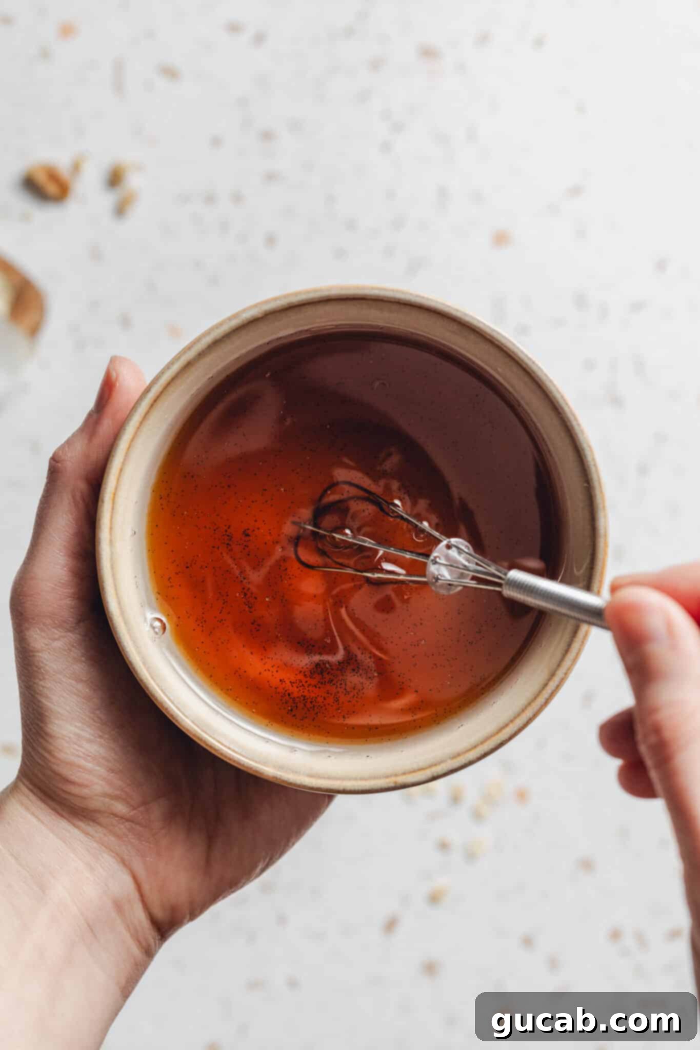 whisking a bowl of coconut oil, maple syrup and vanilla together.