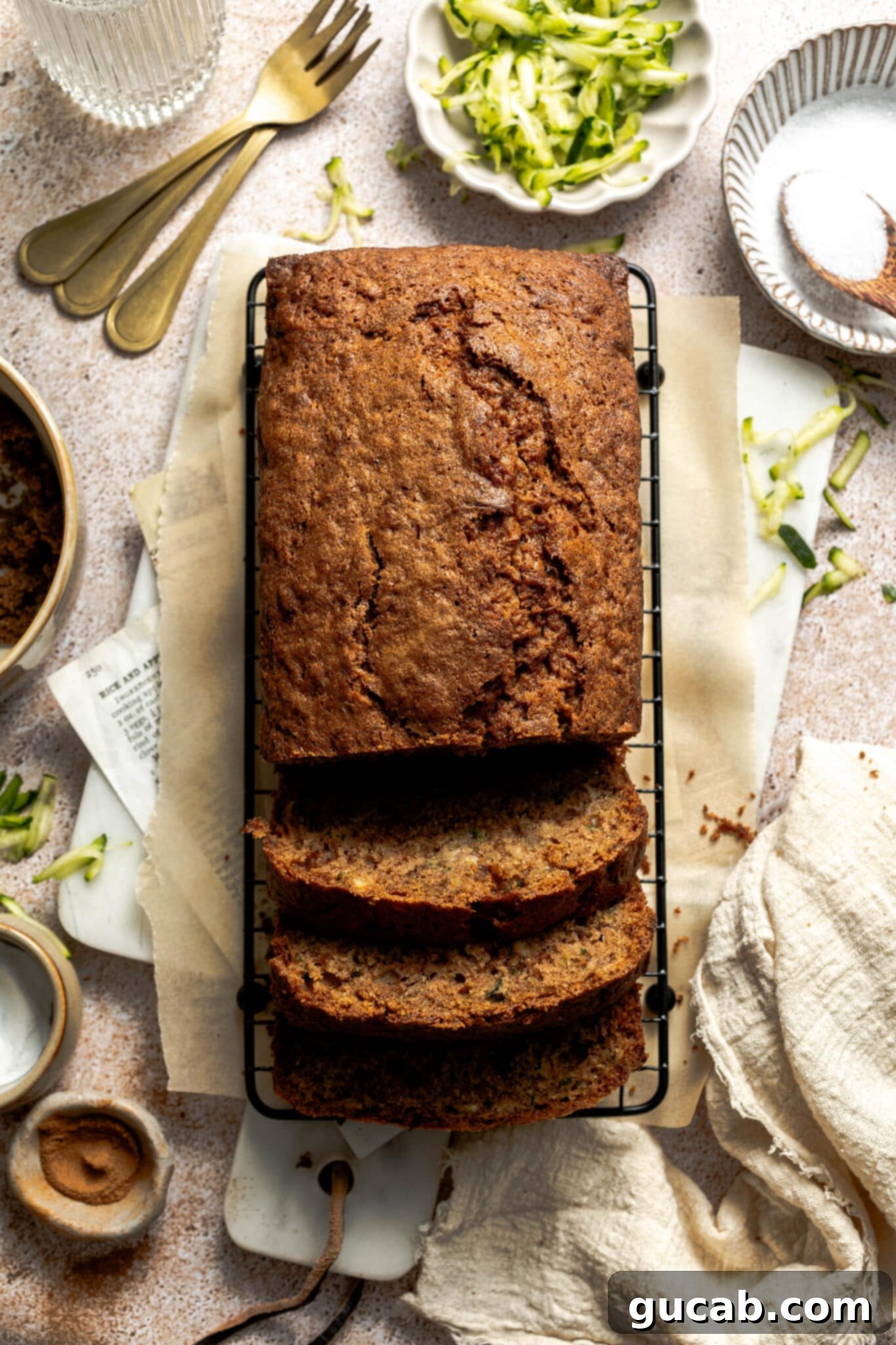 Several thick slices of golden-brown gluten-free zucchini bread resting on a wire cooling rack, showing off its moist interior and perfect bake.