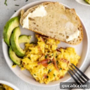 Savory Prosciutto & Cheese Scramble 16 a plate with scrambled eggs, sliced avocado, and buttered toast.