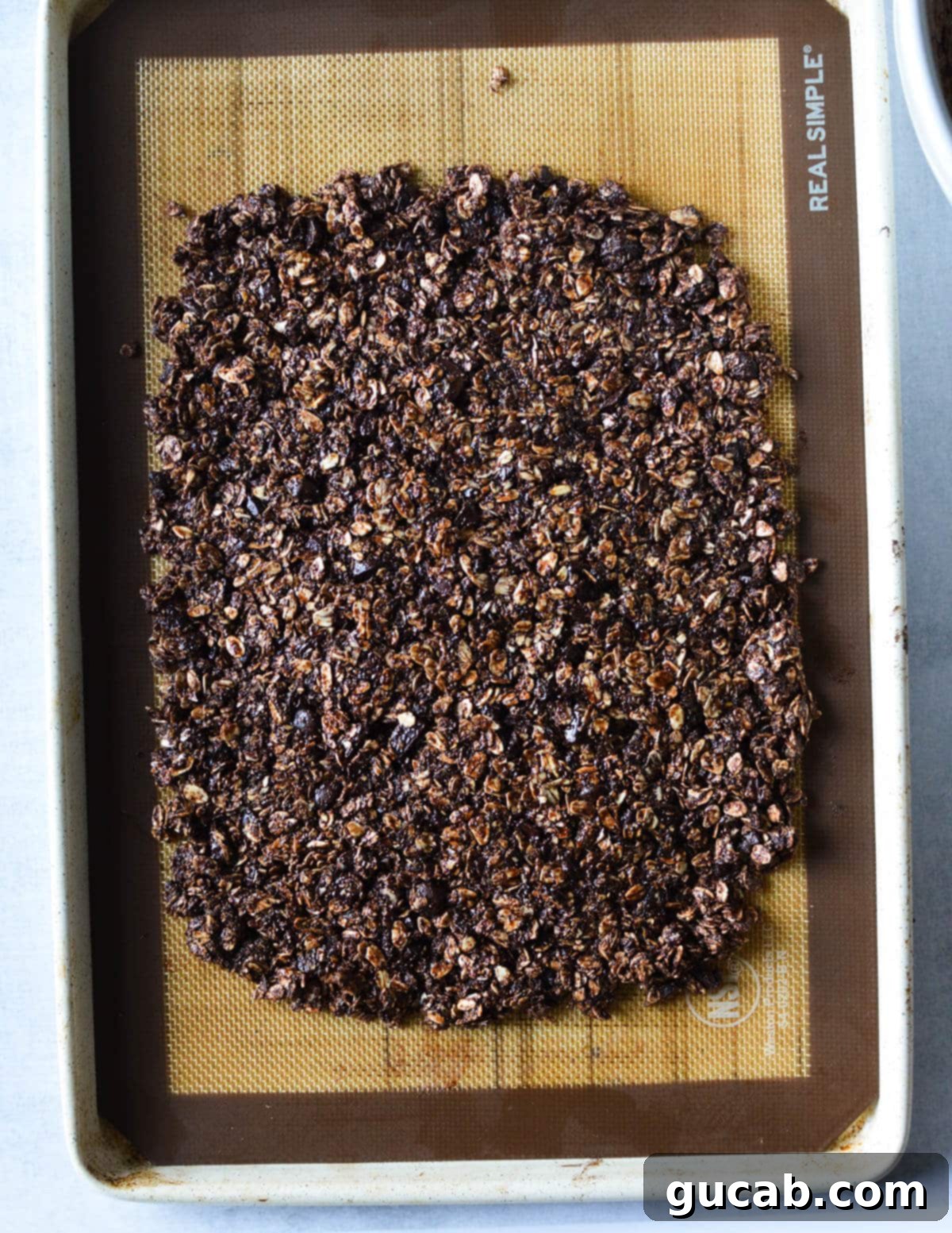 Dark Chocolate Granola 13 A large, even rectangle of unbaked chocolate granola pressed onto a sheet pan, ready to go into the oven.