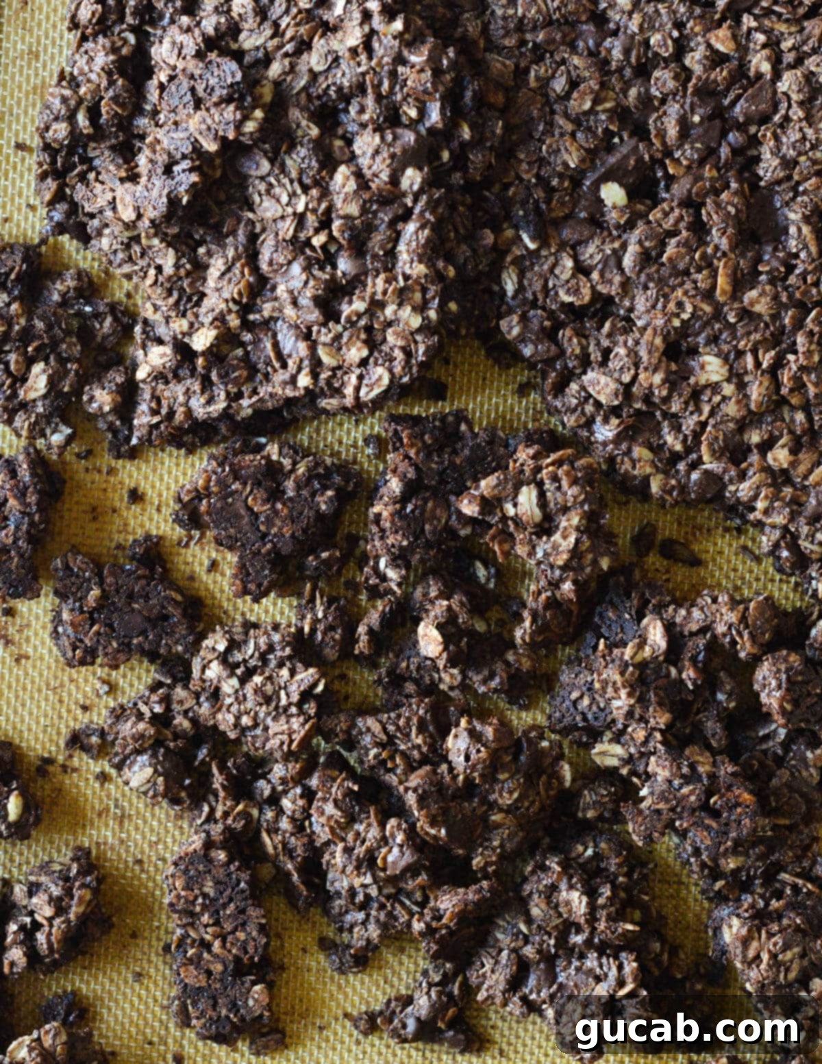Dark Chocolate Granola 15 Large, irregular chocolate granola pieces on a sheet pan, showcasing the cluster formation after initial cooling.