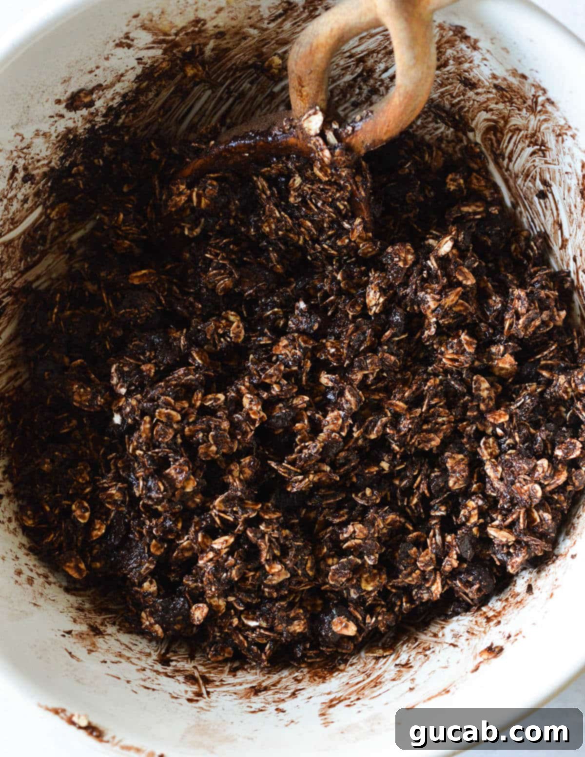 Dark Chocolate Granola 10 The thoroughly mixed wet and dry chocolate granola ingredients in a bowl, showcasing its uniform texture and readiness for baking.