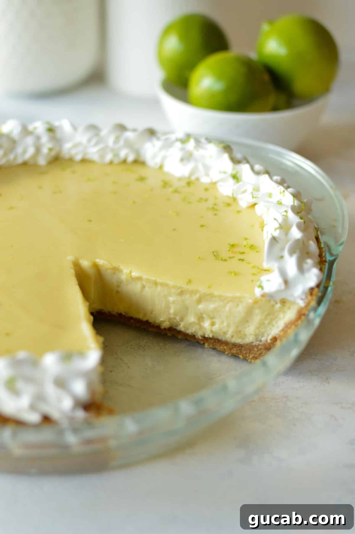 A slice removed from a beautifully baked gluten-free key lime pie, revealing its creamy texture.