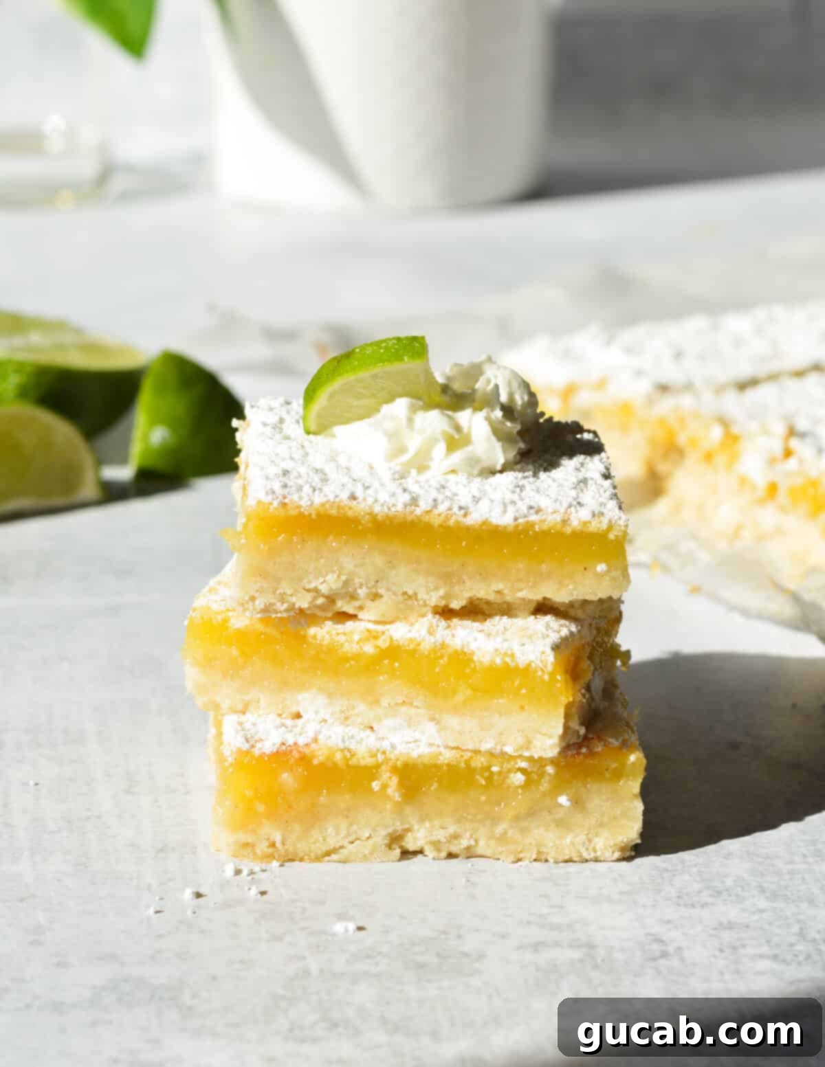 A stack of perfectly cut gluten-free key lime bars, showcasing their vibrant green filling and golden crust.