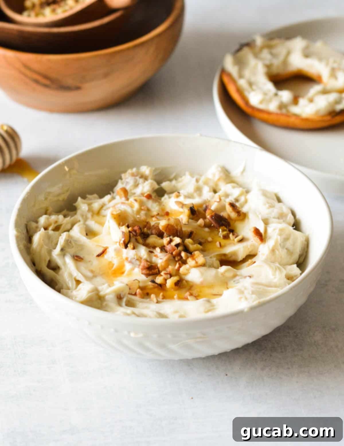 A beautifully presented bowl of honey walnut cream cheese, garnished with a generous sprinkle of chopped walnuts and a golden drizzle of honey, ready to be enjoyed.