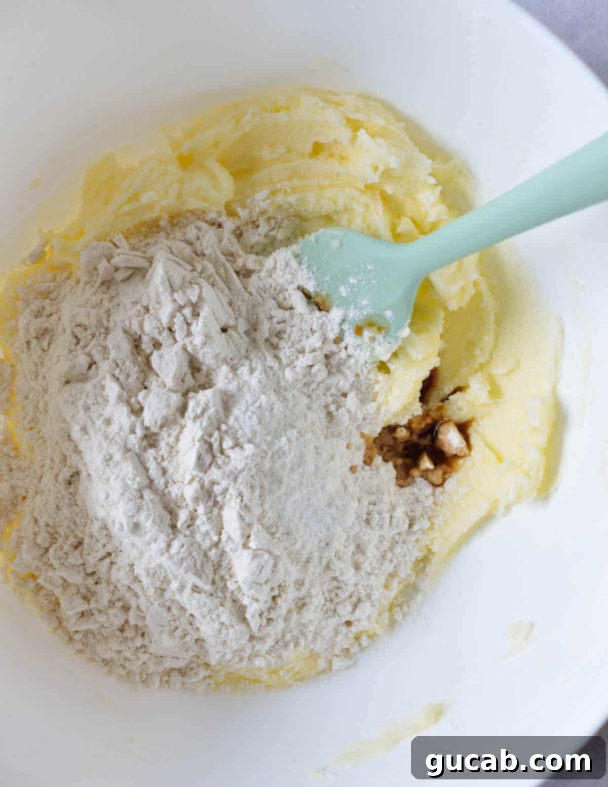 Buttery Gluten-Free Shortbread 6 a bowl of creamed butter and sugar with gluten-free flour on top.