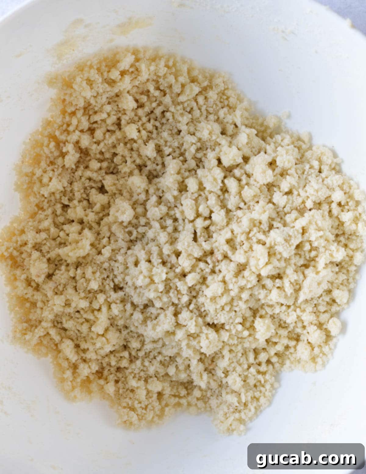 Buttery Gluten-Free Shortbread 7 a bowl of gluten free flour, butter, and sugar mixed together in crumbles.
