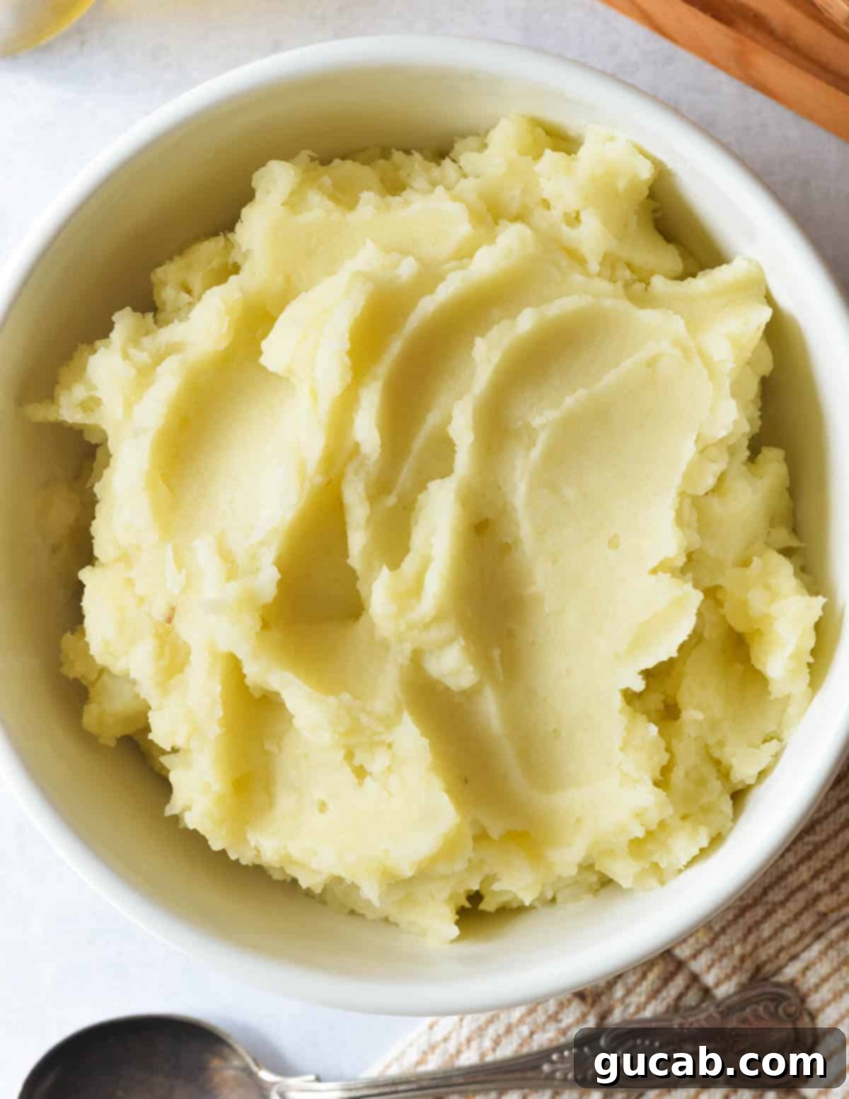 A close-up view of creamy olive oil mashed potatoes in a bowl, showing their smooth and inviting texture.