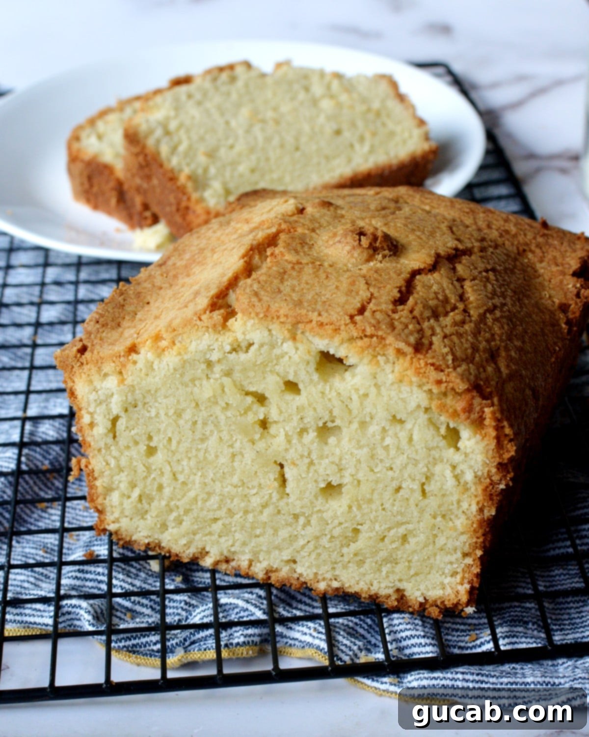 A beautifully presented slice of gluten free sour cream pound cake on a plate.