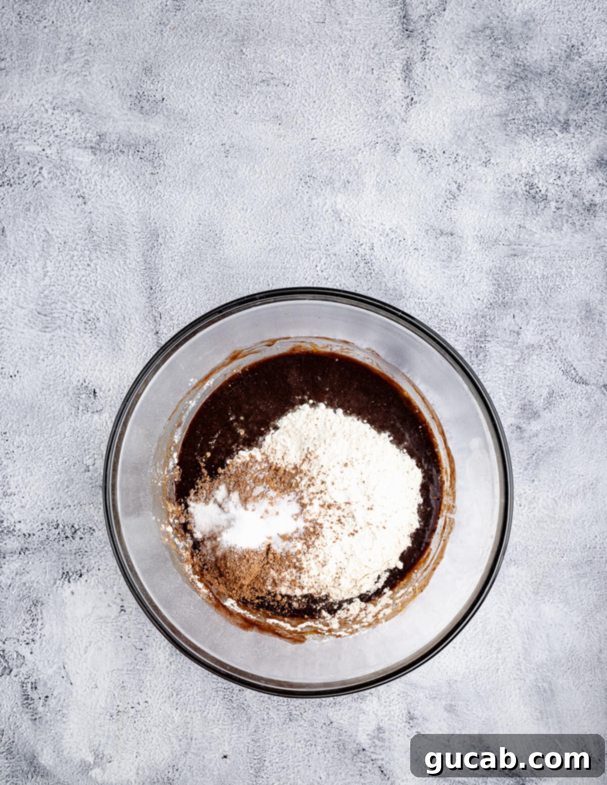 Flour and dark cocoa powder gently sifted over the wet chocolate cookie dough mixture.