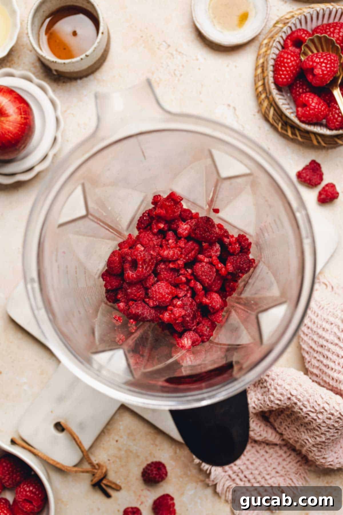 Frozen raspberries added to the blender with bananas and liquid.