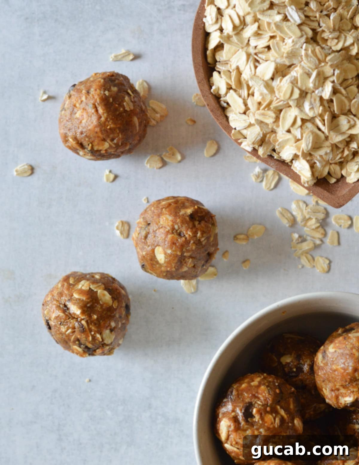 almond butter bites on the counter near a bowl of oats. 