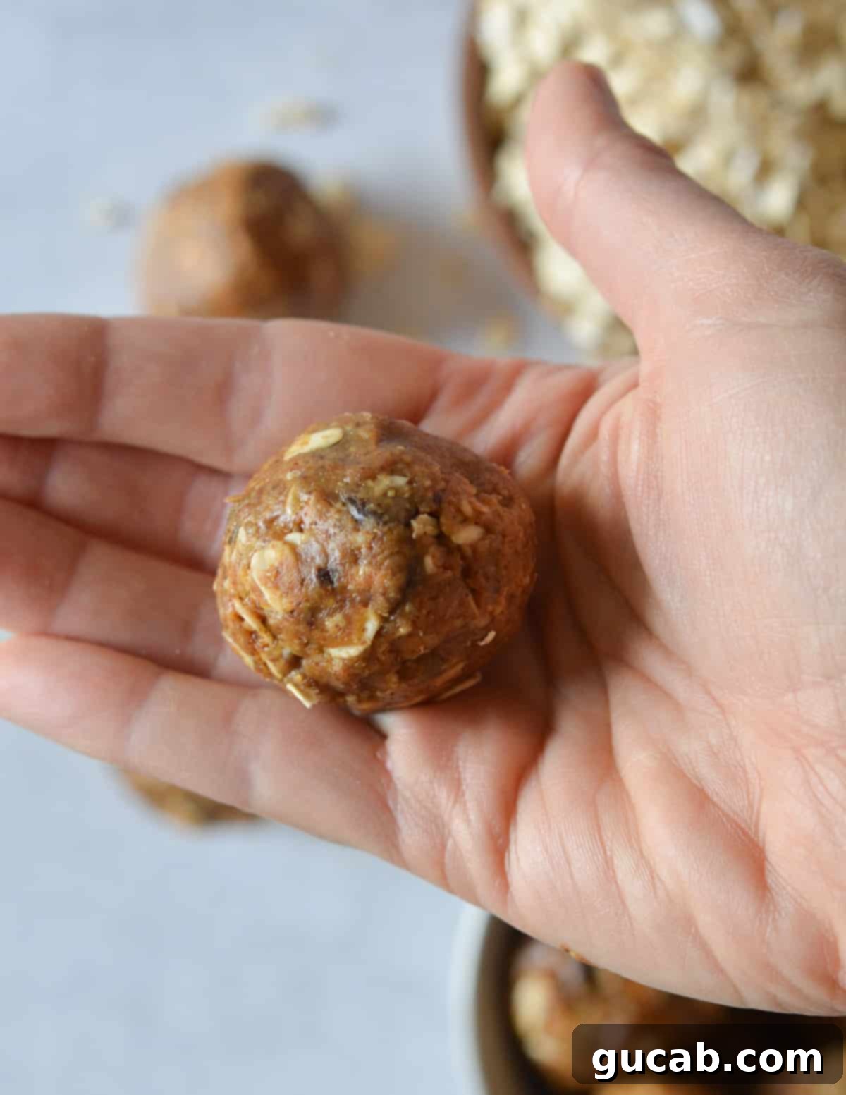 hand holding an almond butter energy ball. 