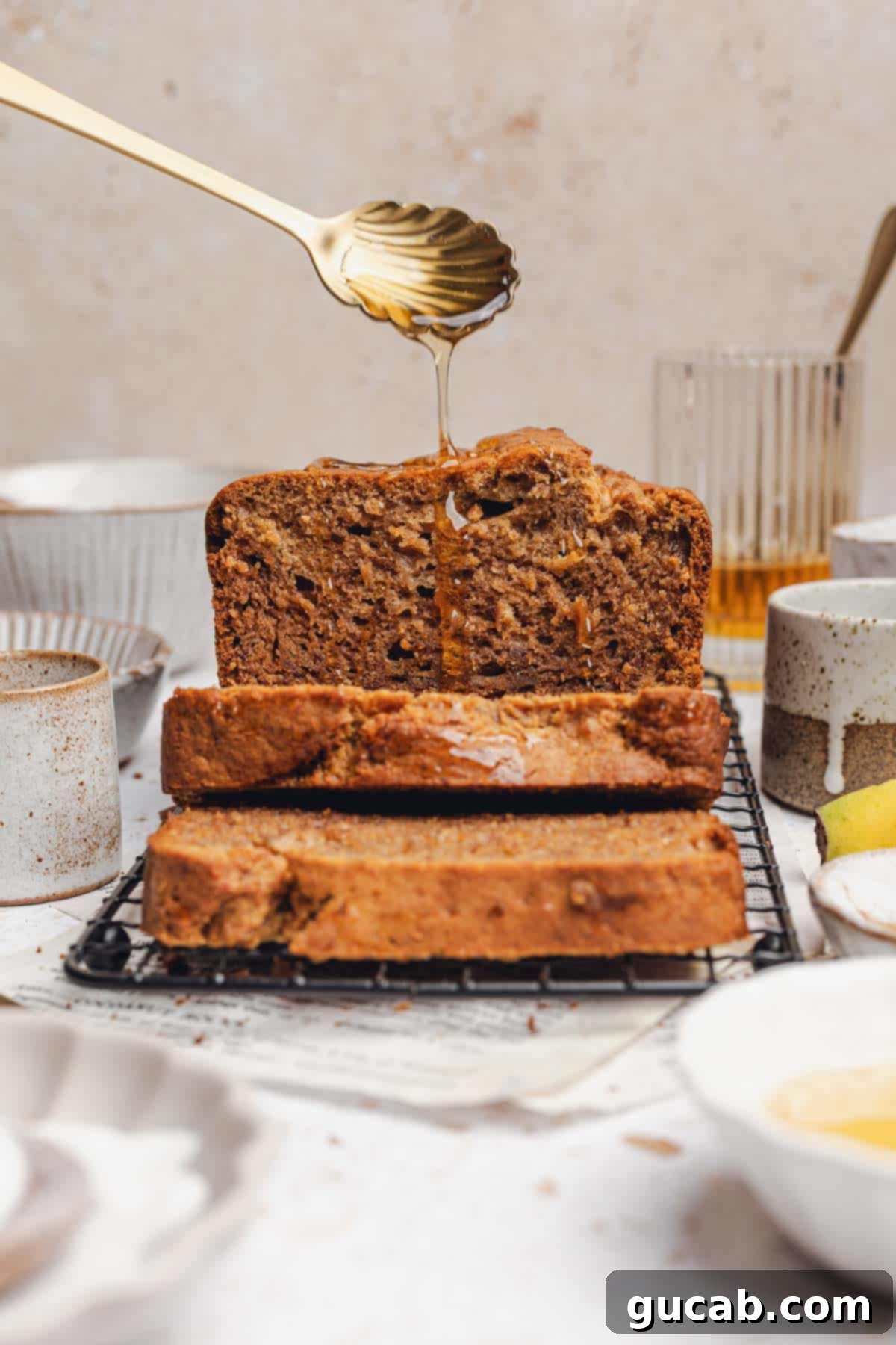 Drizzling golden honey over freshly sliced honey banana bread.