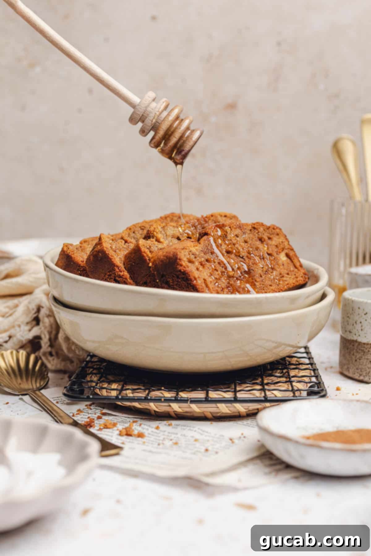 A rustic bowl filled with generous slices of honey banana bread, beautifully drizzled with extra honey.