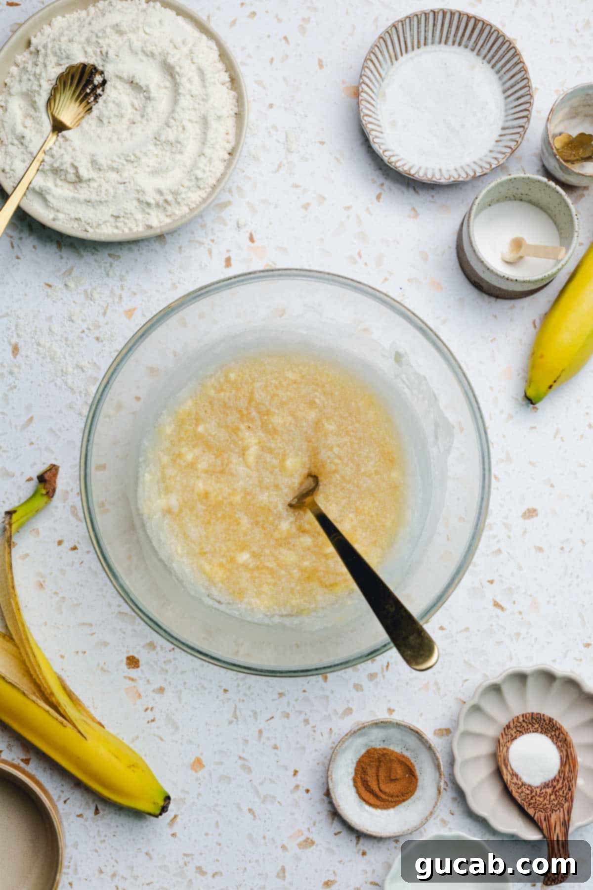A bowl containing a well-mixed blend of mashed banana, coconut oil, and honey, ready for the next step.