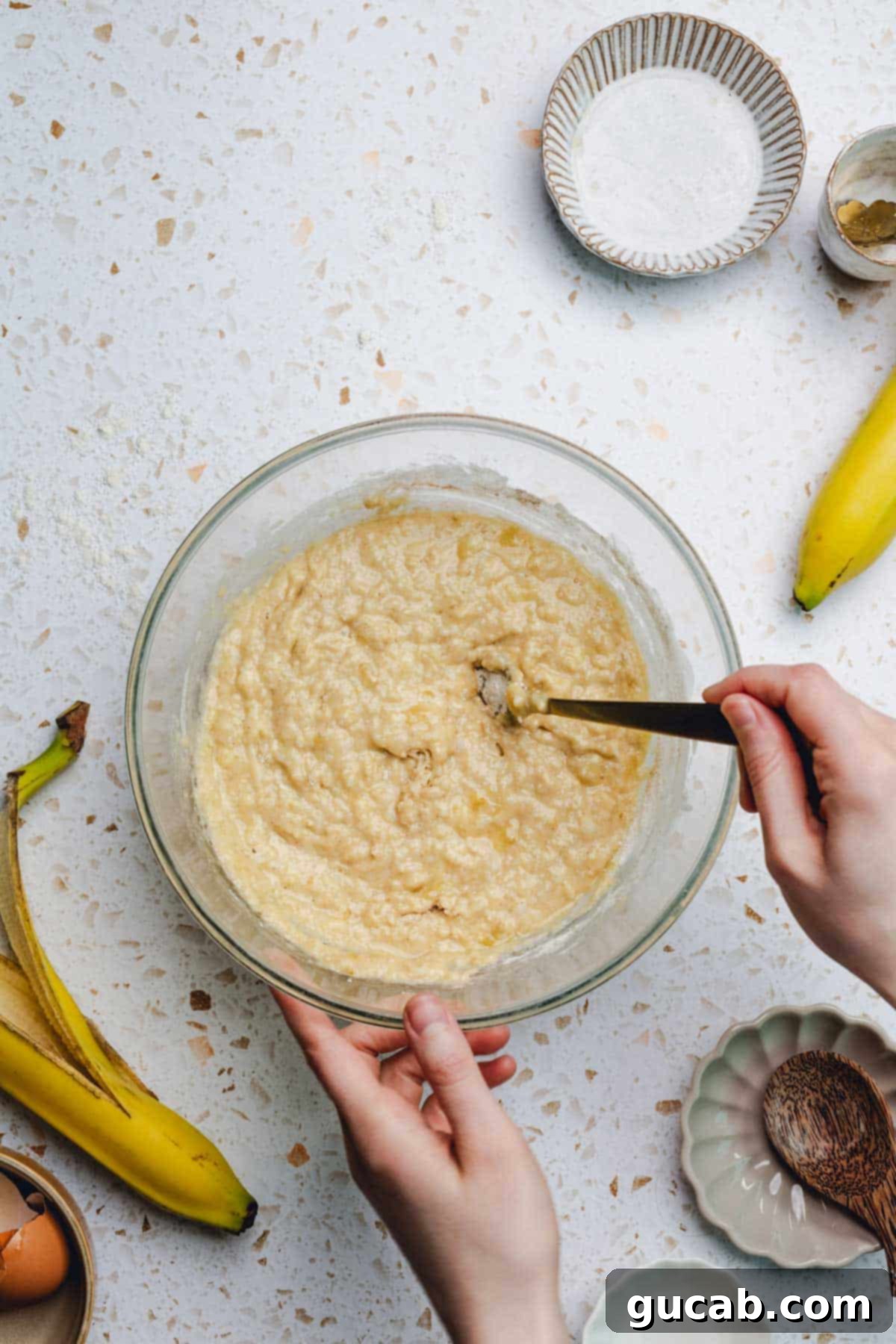 A large bowl filled with smooth, thick honey banana bread batter, ready for baking.