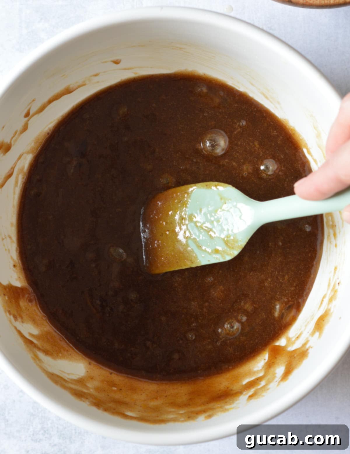 a bowl with browned butter, eggs, and brown sugar mixed together.