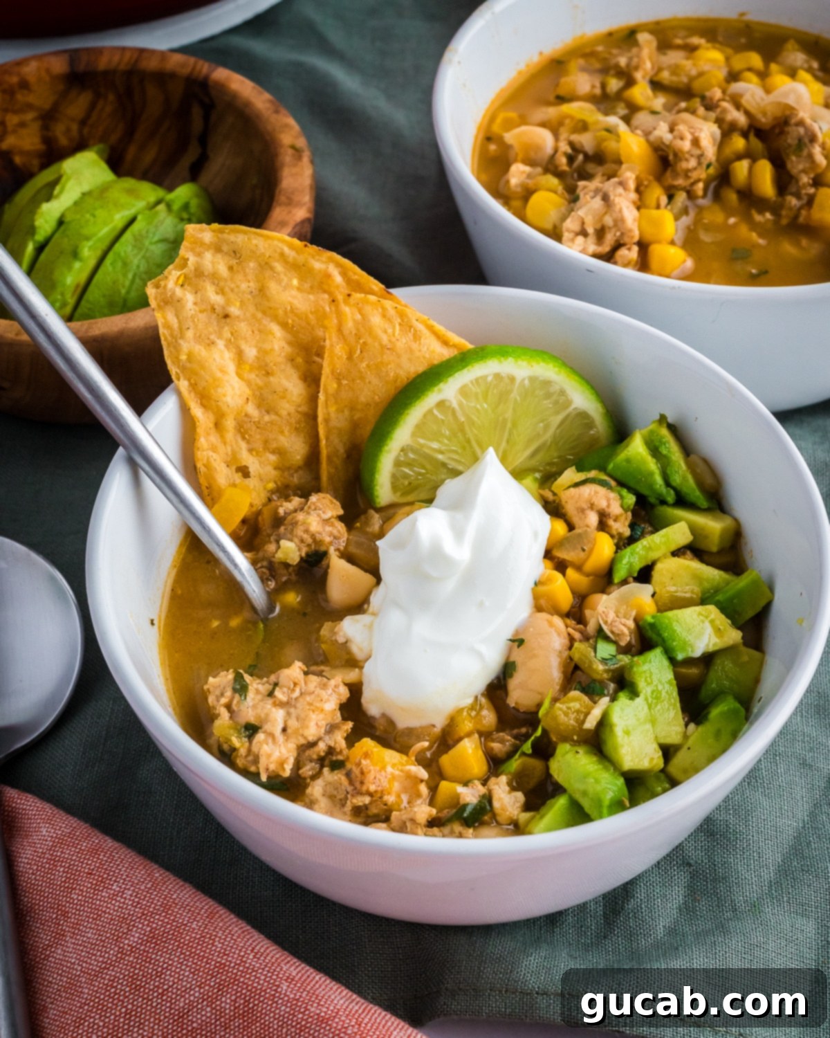 Creamy White Ground Chicken Chili 2 A bowl of creamy white ground chicken chili, garnished with fresh cilantro and a dollop of sour cream.