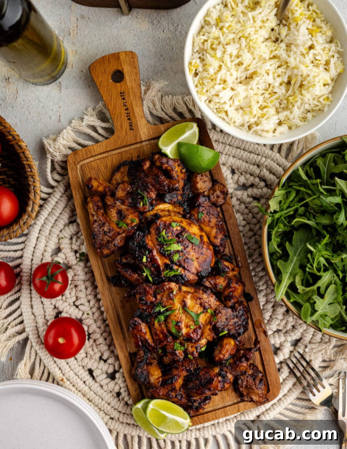 Freshly cooked honey chipotle chicken thighs resting on a cutting board, garnished with bright green lime wedges, ready to be sliced.