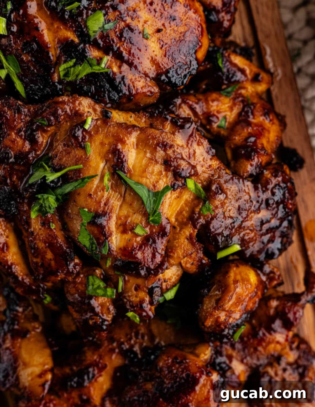 A close-up of a skillet filled with perfectly caramelized and sticky honey chipotle chicken thighs.