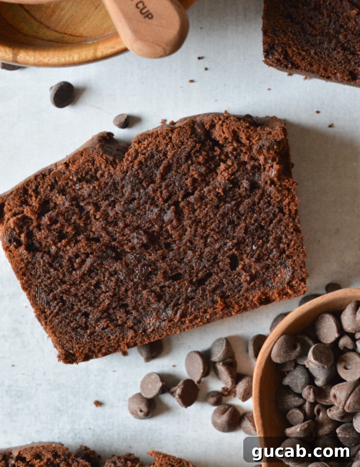 Decadent Gluten-Free Chocolate Pound Cake 13 A perfectly sliced piece of gluten-free chocolate pound cake, rich and moist, next to a small bowl of chocolate chips.