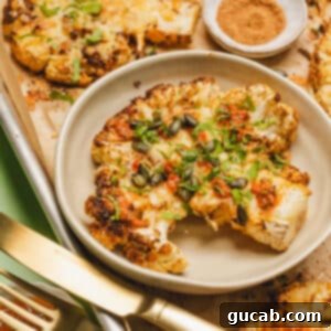 cheesy cauliflower steak with salsa and pepitas on top.