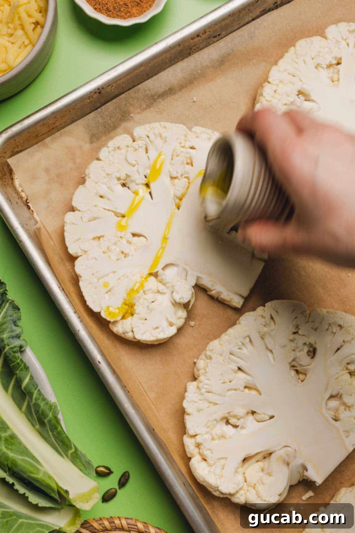drizzling olive oil onto slices of cauliflower on a sheet pan. 