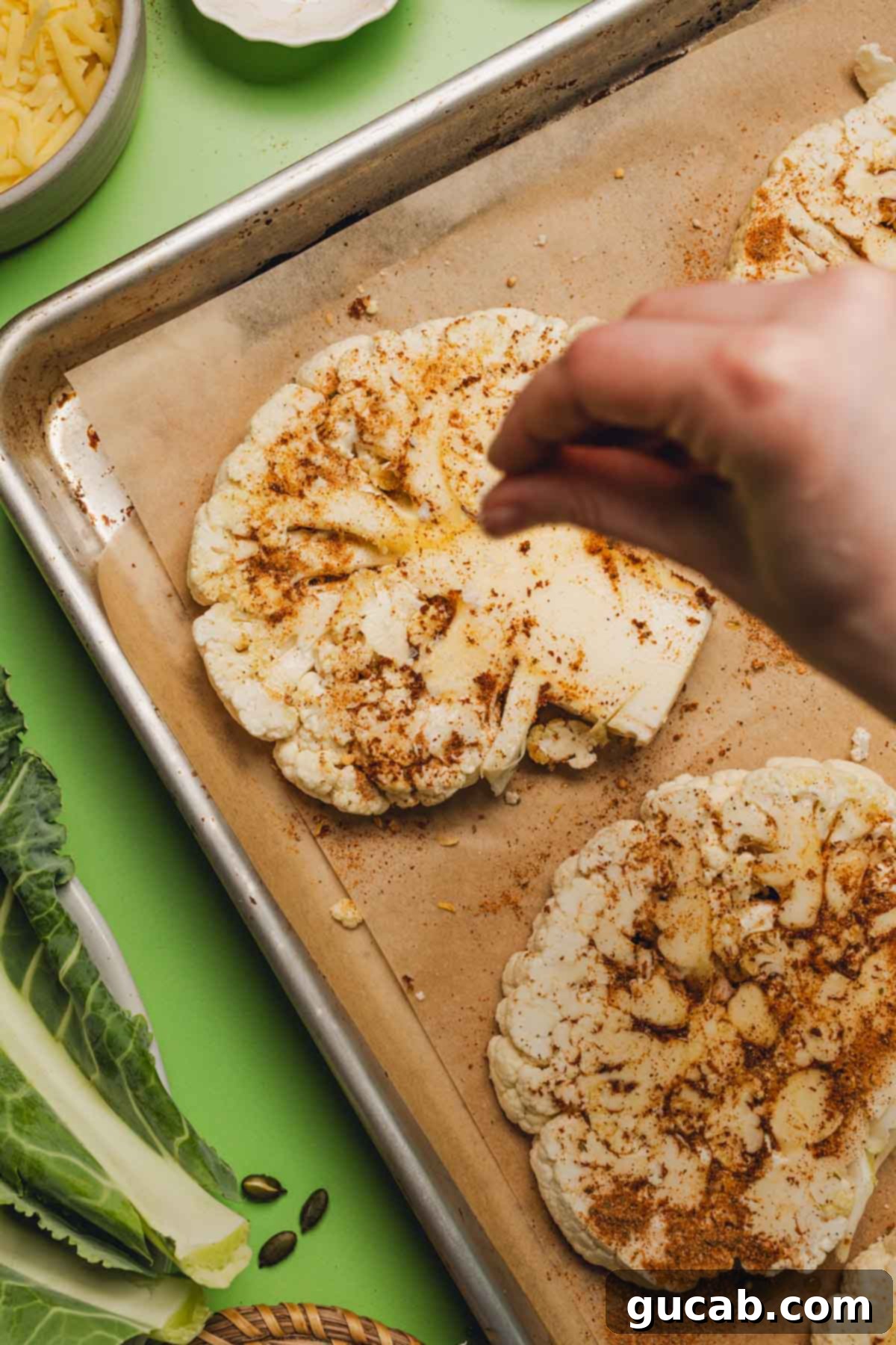 sprinkling kosher salt onto seasoned cauliflower steaks. 