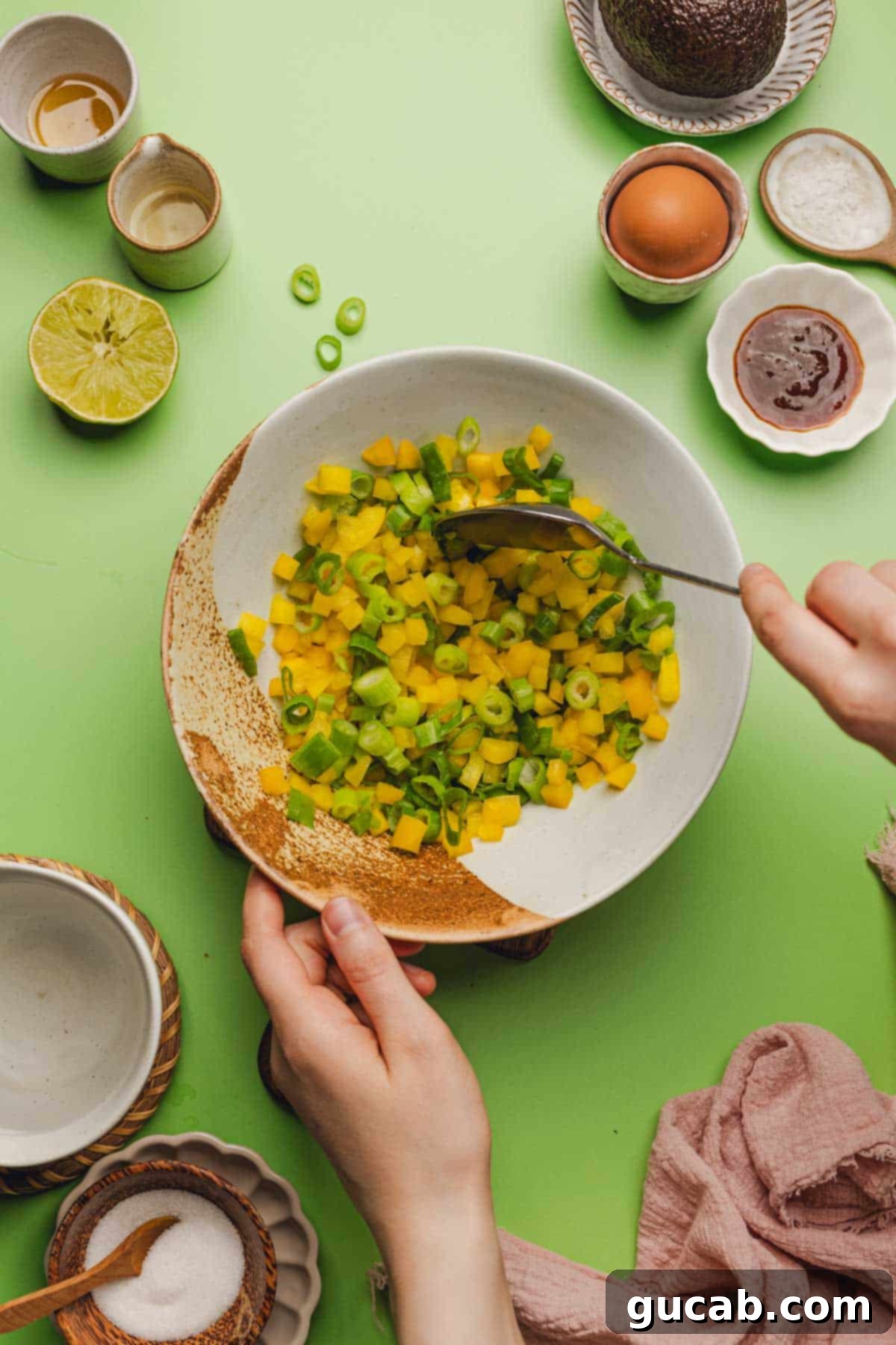 a bowl of diced yellow bell peppers and sliced green onions. 