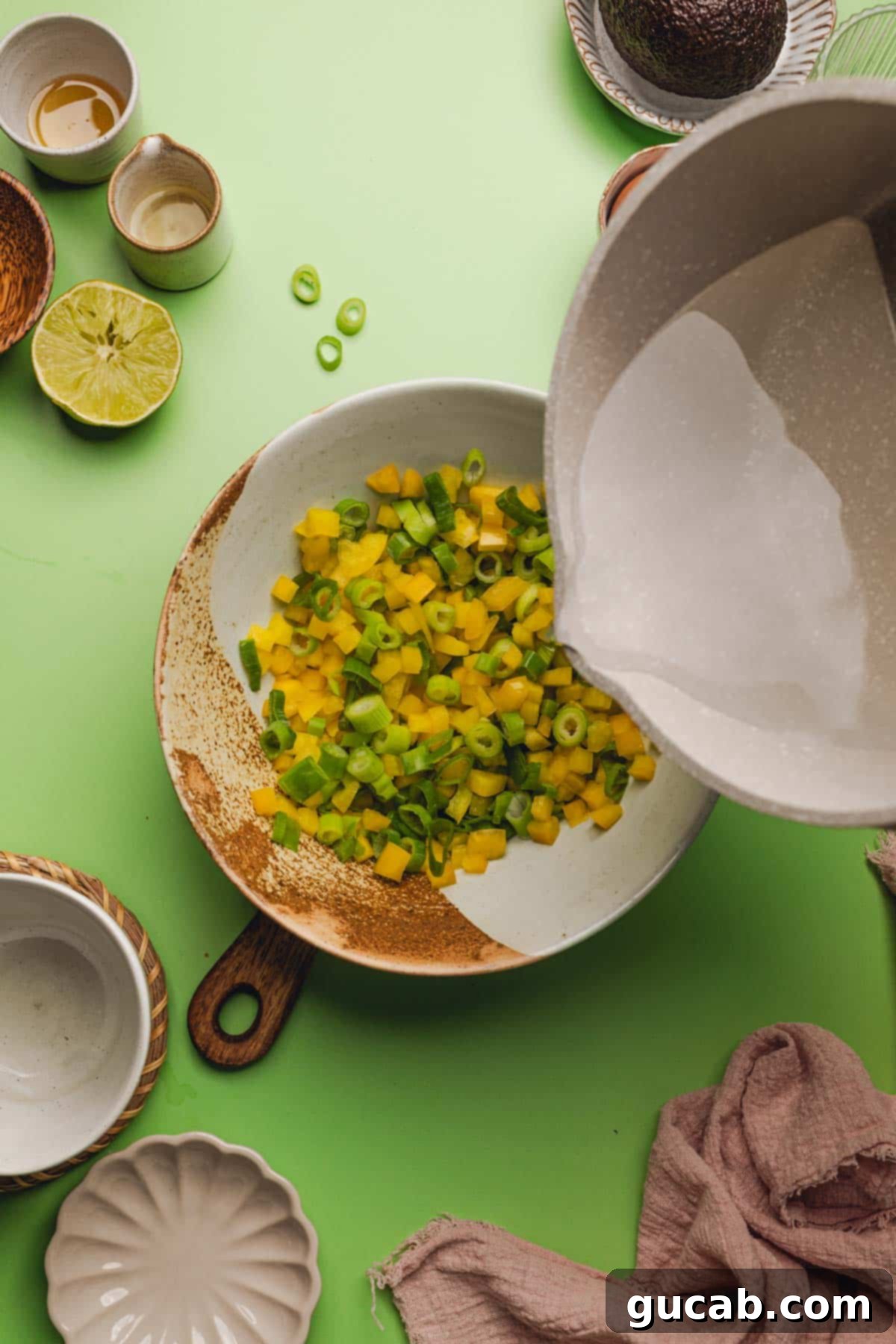 pouring hot vinegar mixture over bell peppers and green onions. 