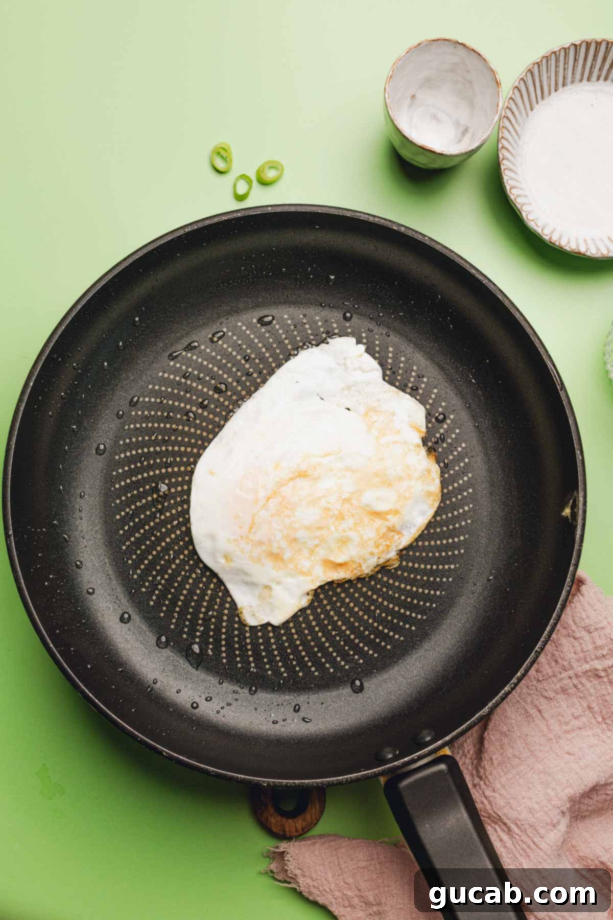 A perfectly fried egg with a firm white and runny yolk, just cooked in a skillet.