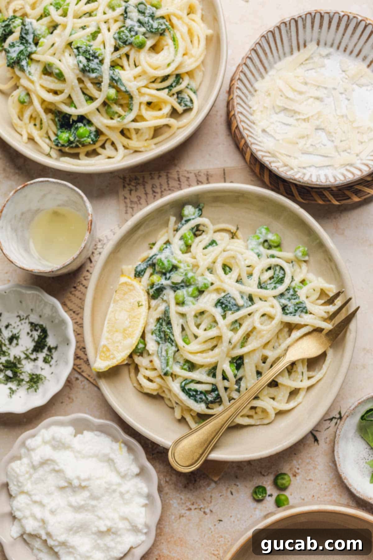 A beautifully plated dish of lemon ricotta pasta, featuring a gold fork and a fresh lemon wedge, ready to be enjoyed.