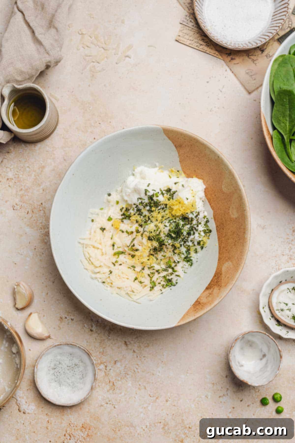 A bowl containing a mix of Parmesan, fresh basil, dill, lemon zest, and ricotta cheese, prepped for the sauce.