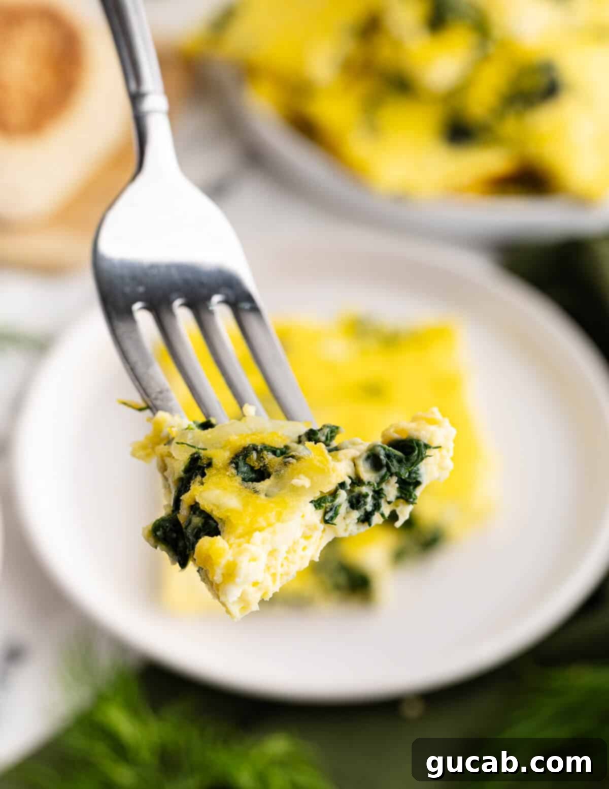 a bite of cooked eggs with spinach and cheese. 